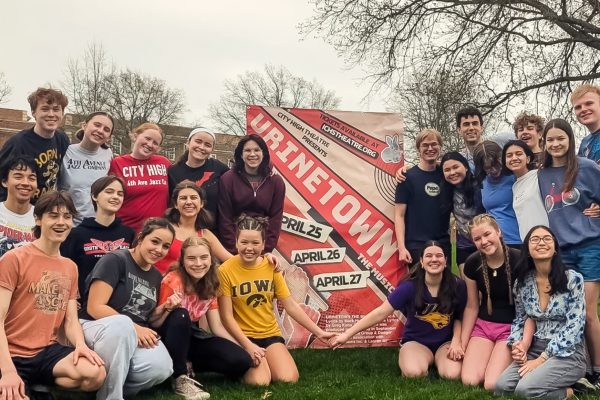 Members of the cast and crew of Urinetown pose in front of City High promoting the musical.
